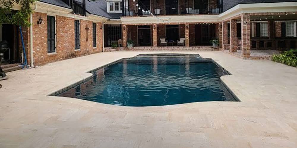 Modern geometric pool with dark plaster finish and brick colonnade