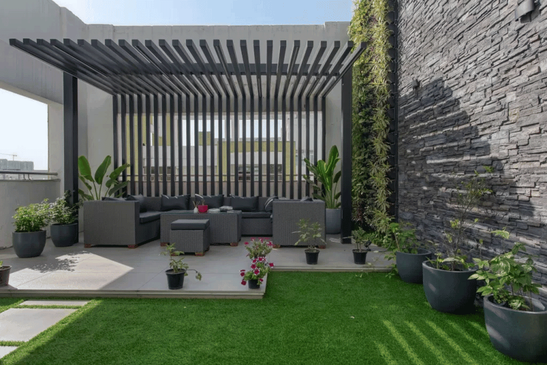 Aluminum pergola with vertical slat wall and outdoor seating.